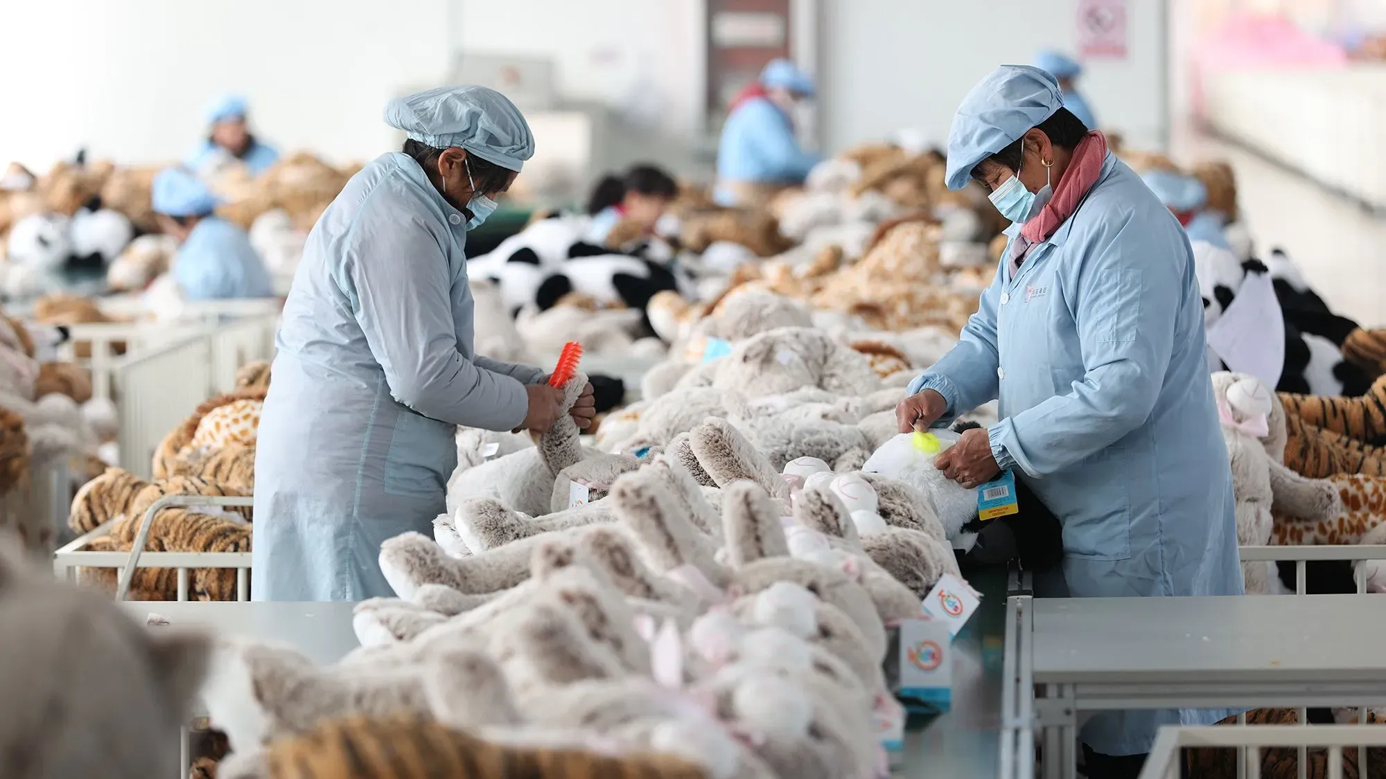 عمال في مصنع للألعاب في الصين يقومون بتجهيز دمى محشوة، وسط تحديات الرسوم الجمركية وتأثيرها على صناعة الألعاب في الولايات المتحدة.