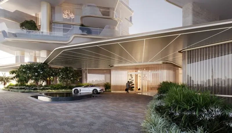 مدخل مشروع ريجنت ريزيدنسز دبي، يتضمن تصميمًا عصريًا مع مساحات خضراء وسيارة فاخرة، ويظهر الرفاهية والفخامة المتوقعة.