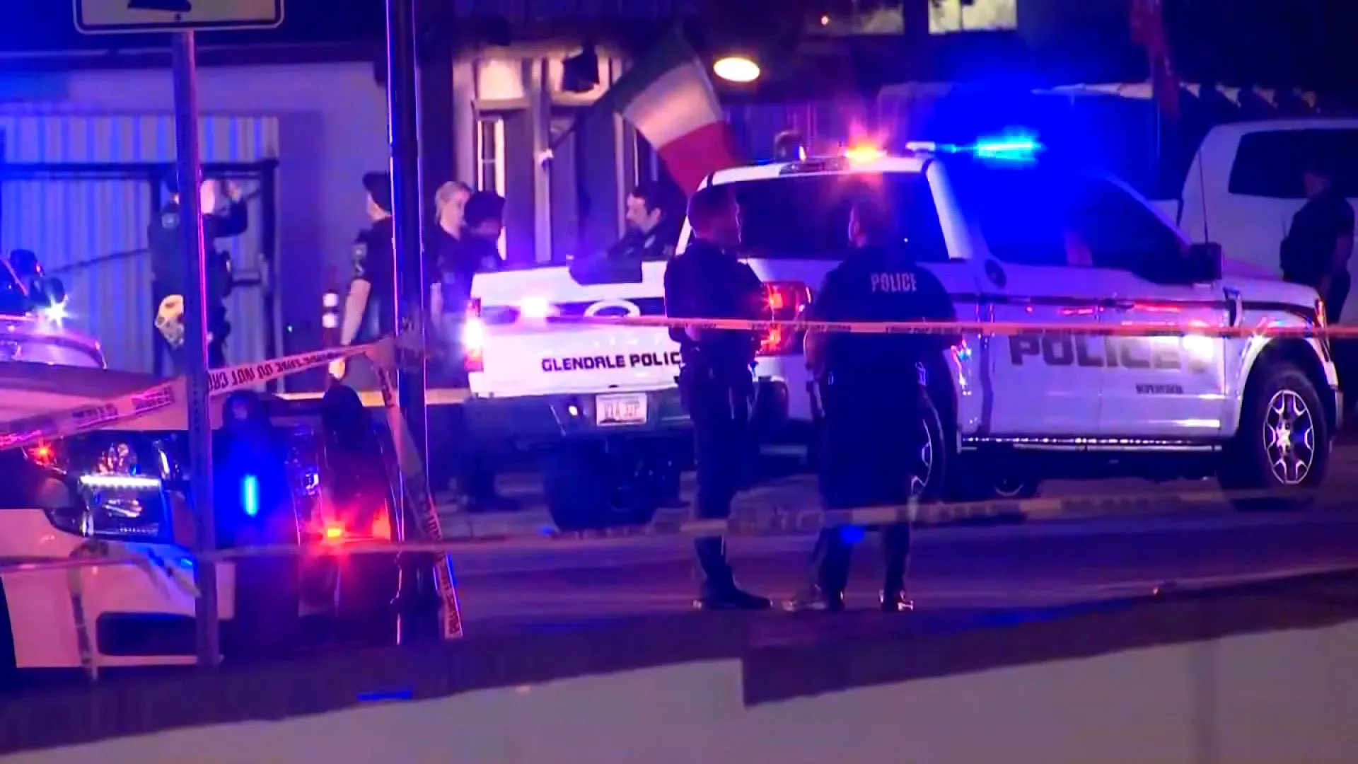 موقع الحادث في مطعم بأريزونا حيث تجمع رجال الشرطة حول سيارة شرطة بينما تتواجد أضواء الطوارئ.