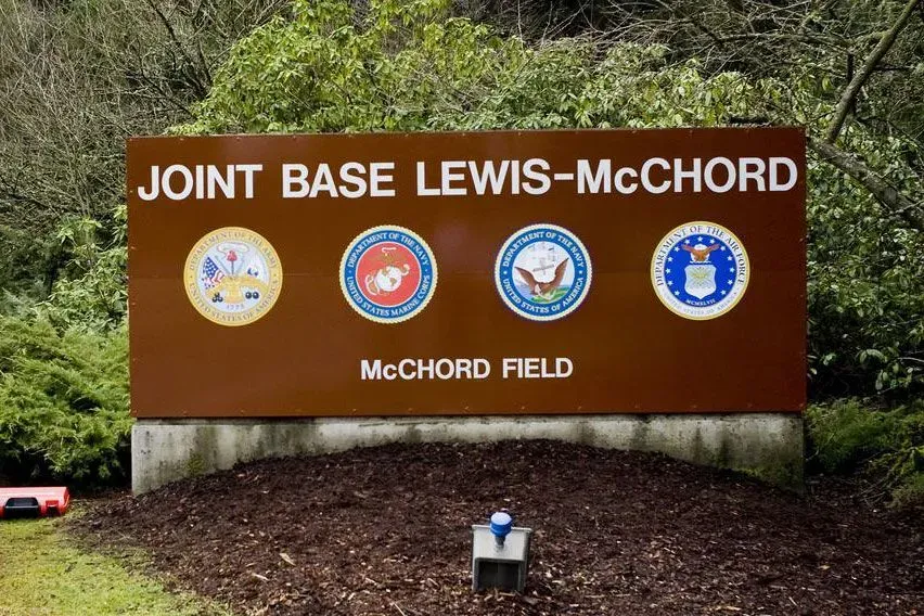 لافتة قاعدة لويس-ماكشورد المشتركة، تظهر شعارات القوات المسلحة الأمريكية، تمثل الموقع الذي شهد تحطم مروحية بلاك هوك.