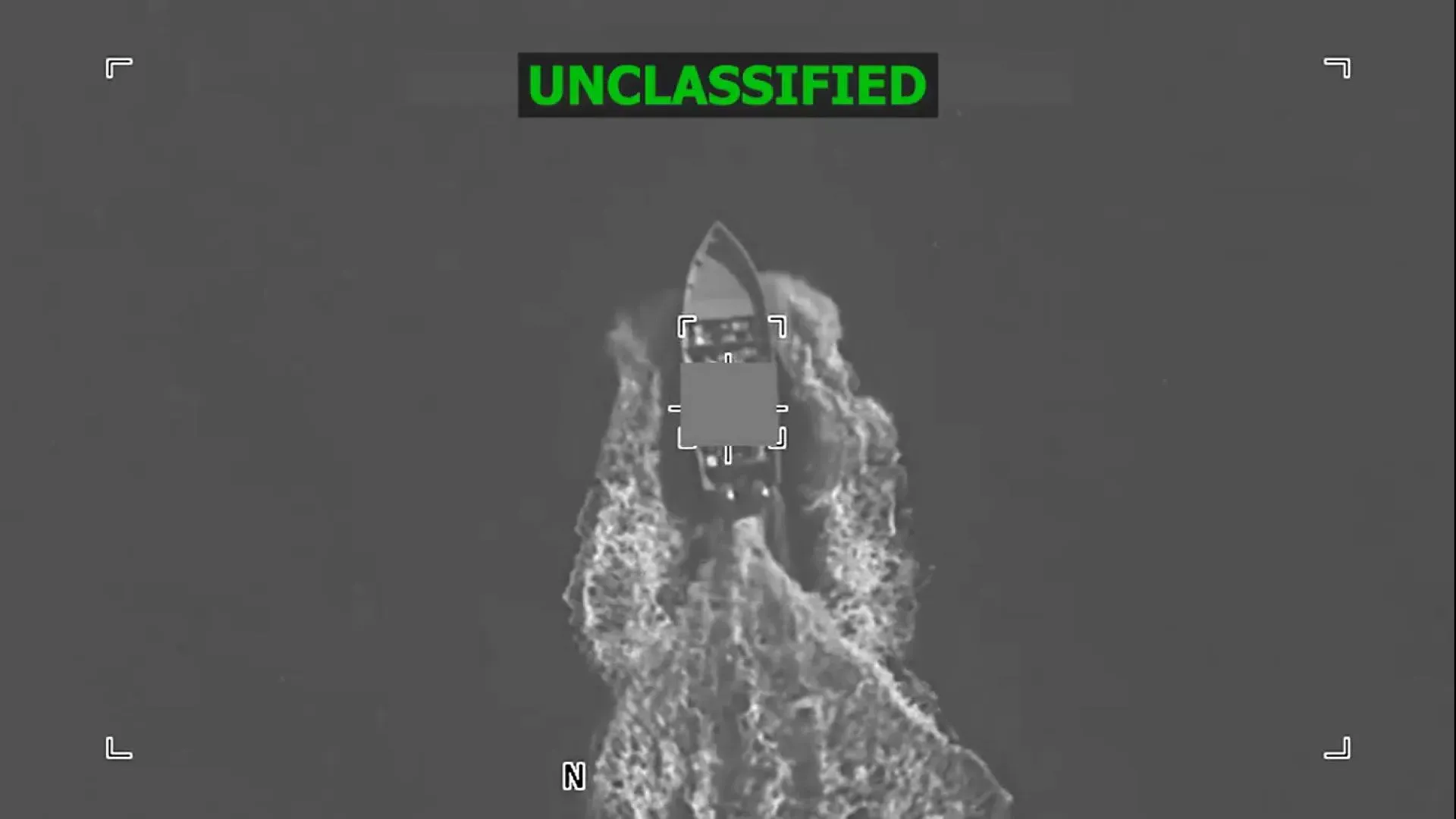 زورق صغير يبحر في البحر، يظهر من منظور جوي مع تفاصيل واضحة عن حركة المياه حوله، مما يعكس النشاط البحري.