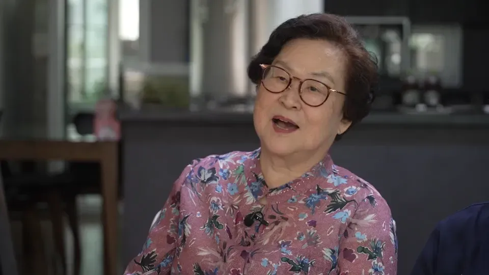 امرأة مسنّة تتحدث في حوار، ترتدي قميصاً مزخرفاً، تعبر عن مشاعرها حول فقدان أخيها خلال الحرب الكورية.