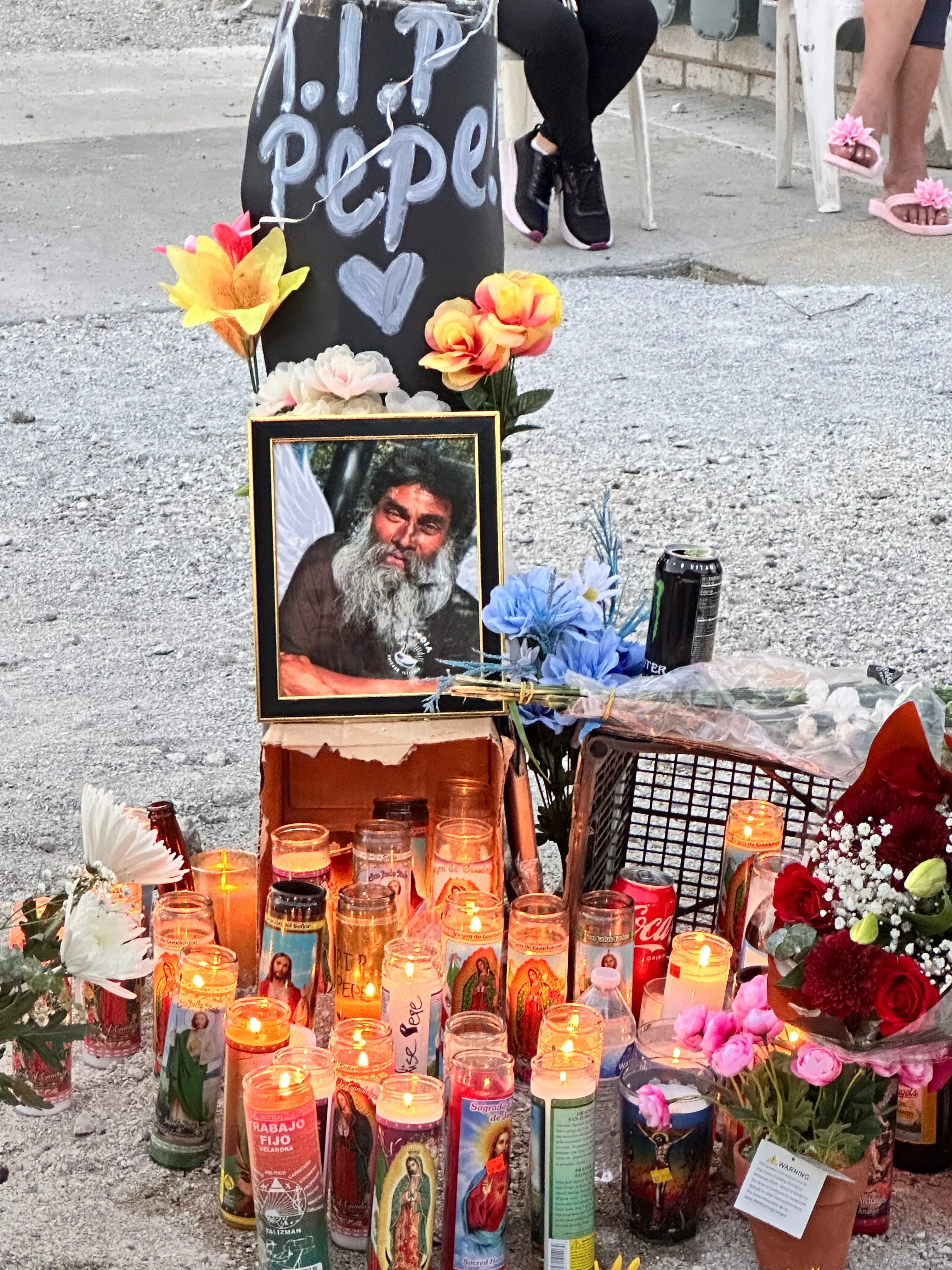 نصب تذكاري لبيبي، رجل مشرد قُتل في شيكاغو، يتضمن صورته، شموعًا مضاءة، وزهورًا، مع لافتة تحمل عبارة "ارقد بسلام".