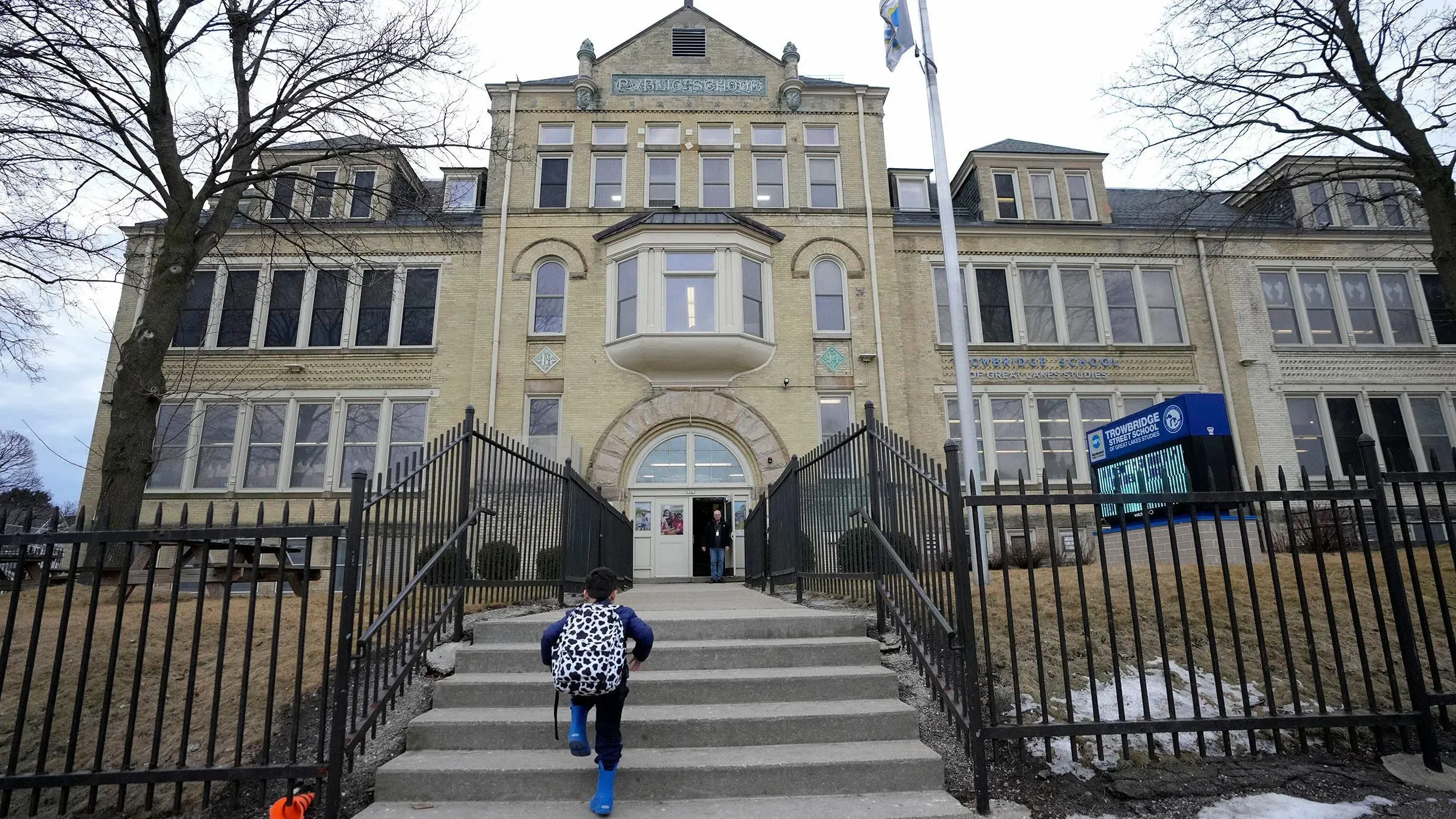 مدرسة قديمة في ميلووكي، حيث يظهر طفل يتجه نحو المدخل. تتعلق الصورة بالتحقيق في مستويات الرصاص في المدارس.