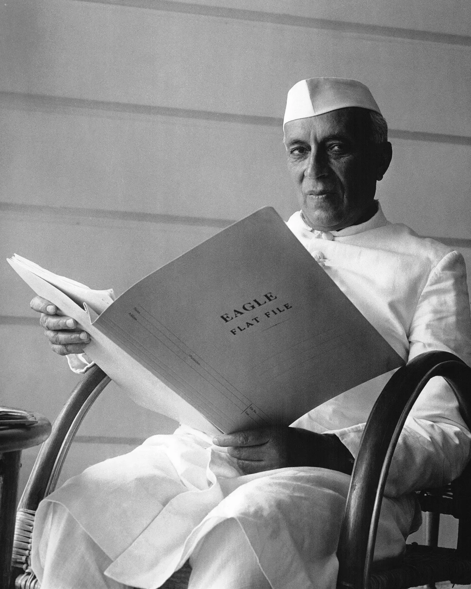 صورة لرئيس الوزراء الهندي جواهر لال نهرو يجلس في كرسي ويقرأ ملفاً يحمل عنوان "EAGLE". تعكس الصورة دور اللغة الإنجليزية في التاريخ الهندي.