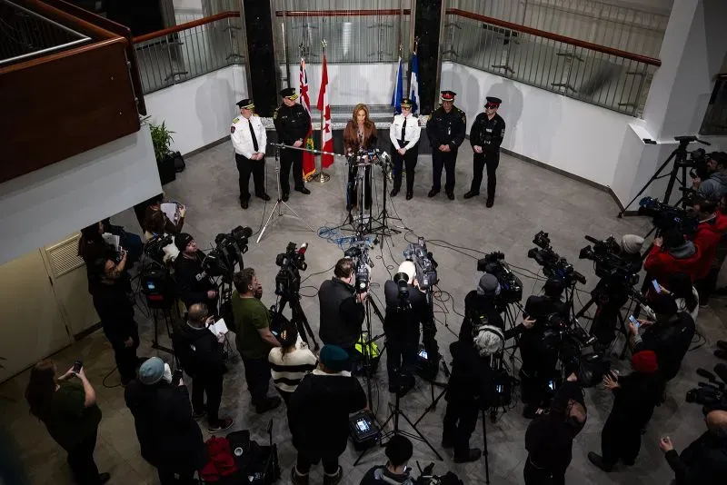 مؤتمر صحفي في مطار تورنتو بيرسون الدولي، حيث تتحدث متحدثة أمام عدد كبير من الصحفيين، مع وجود ضباط شرطة خلفها.