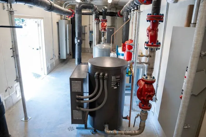 شبكة لتدفئة حرارية أرضية في منشأة بجوار منزل إريك ماوتشان، تتضمن مضخات وأنابيب لتعزيز كفاءة الطاقة وتخفيف تكاليف التدفئة وتبريد المنزل.