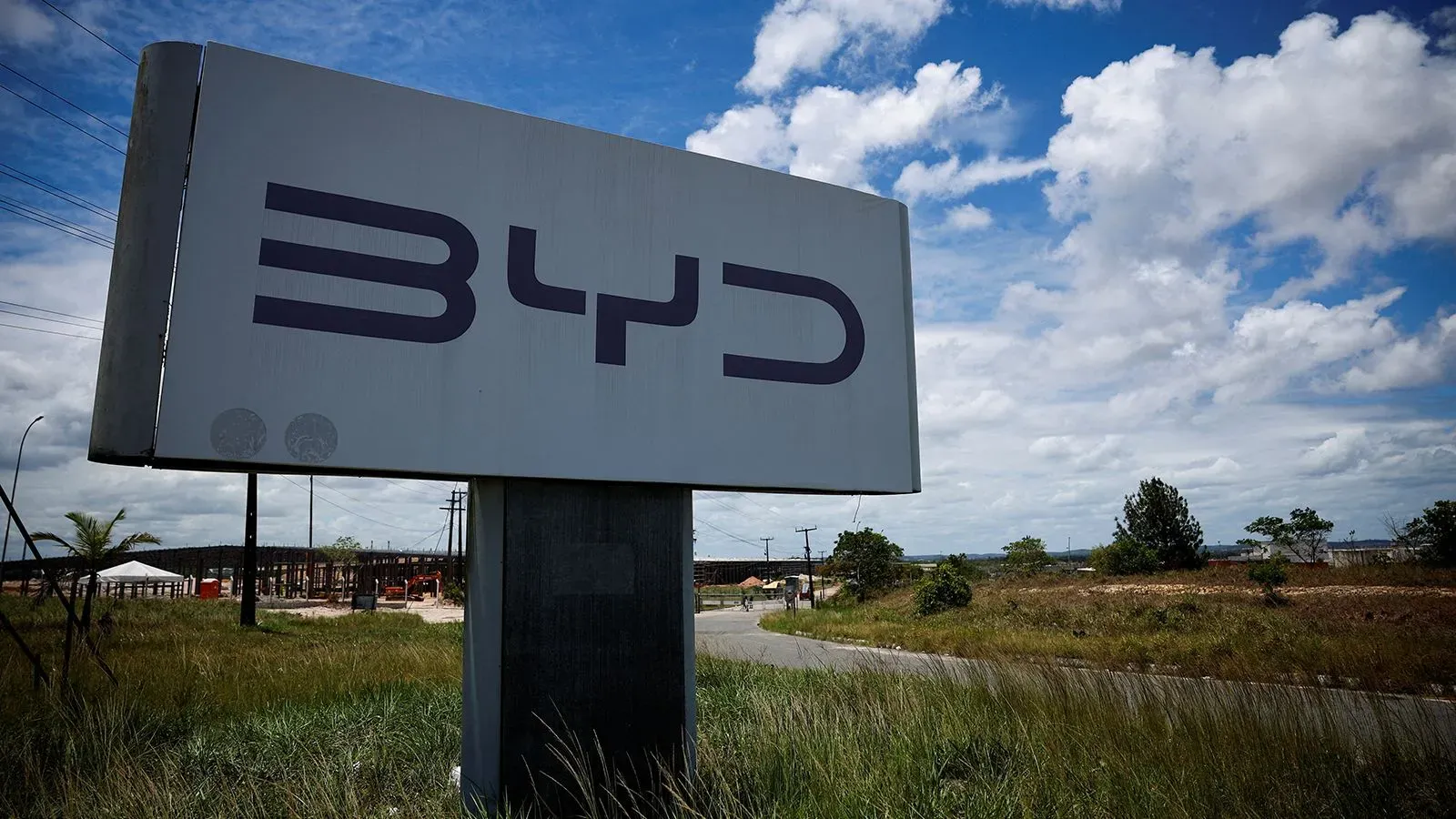 لافتة شركة BYD تظهر شعارها على خلفية سماء زرقاء، مما يعكس الابتكار في صناعة السيارات الكهربائية في الصين.