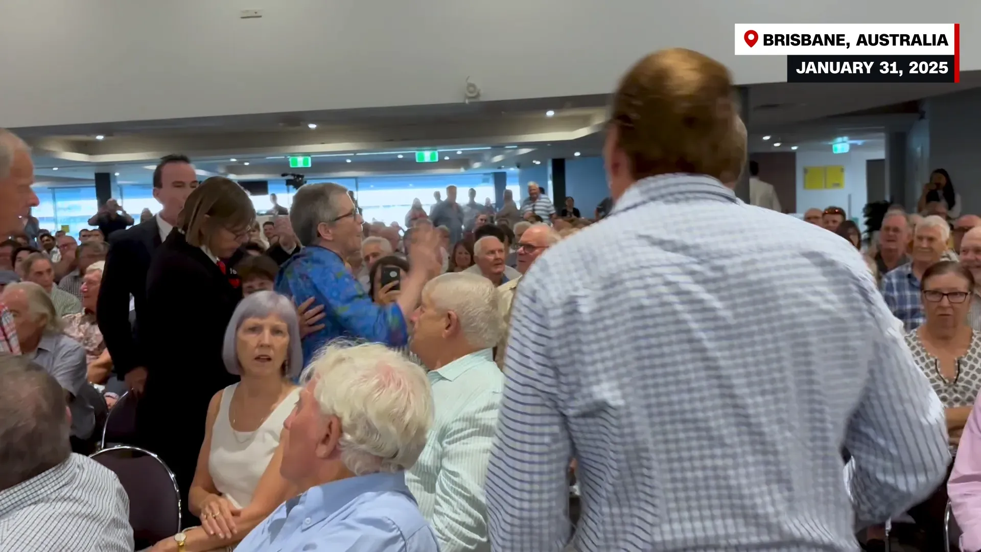 غريس ستانكه تتحدث أمام حشد كبير في بريسبان، أستراليا، خلال جولة لدعم الطاقة النووية، وسط تفاعل متباين من الجمهور.