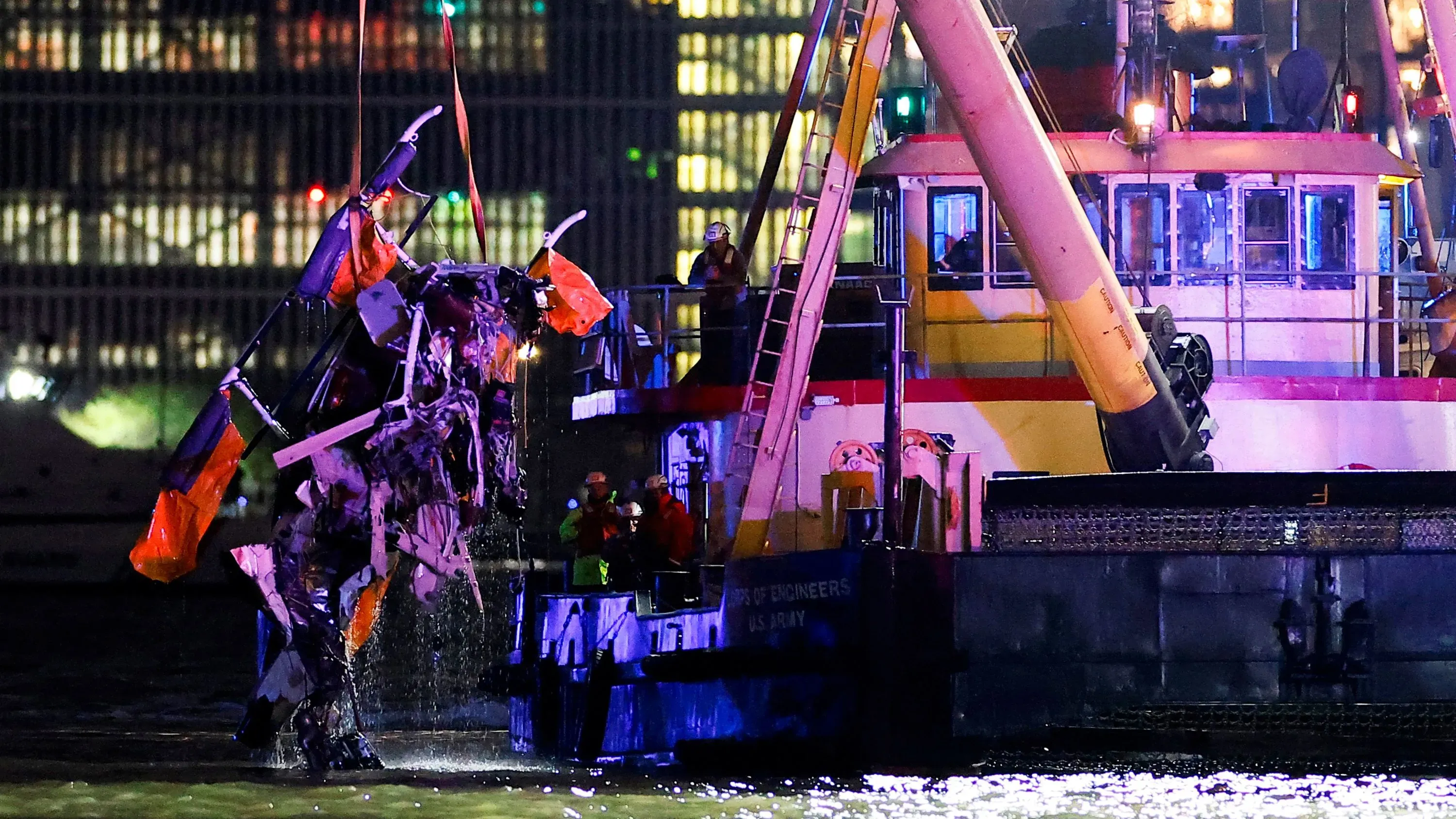 انتشال حطام طائرة هليكوبتر من نهر هدسون بعد تحطمها، مع وجود فرق الإنقاذ في موقع الحادث وسط أضواء المدينة.