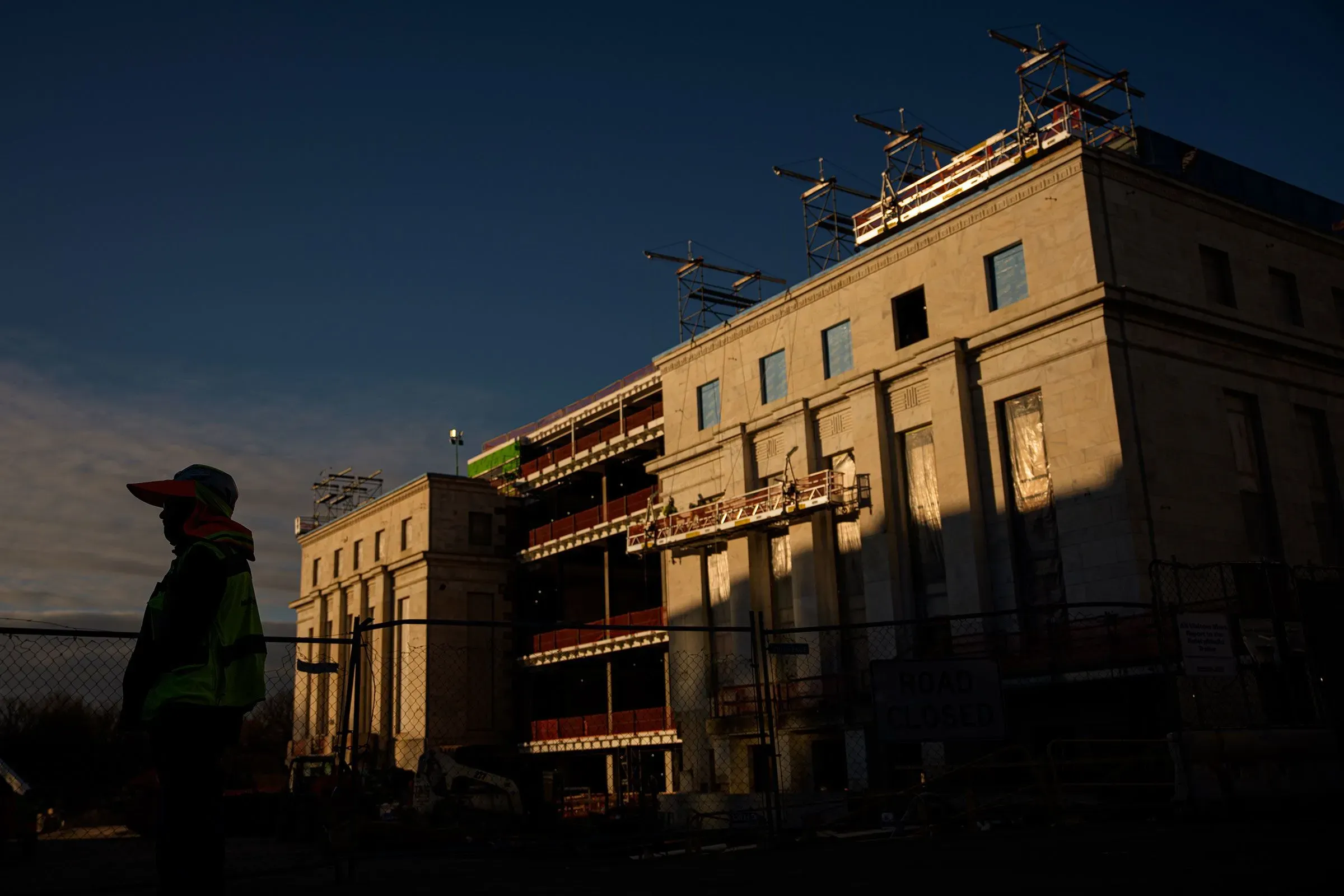 مبنى قيد الإنشاء لمجلس الاحتياطي الفيدرالي، مع عامل يرتدي خوذة واقية، يعكس أهمية القرارات الاقتصادية في البلاد.