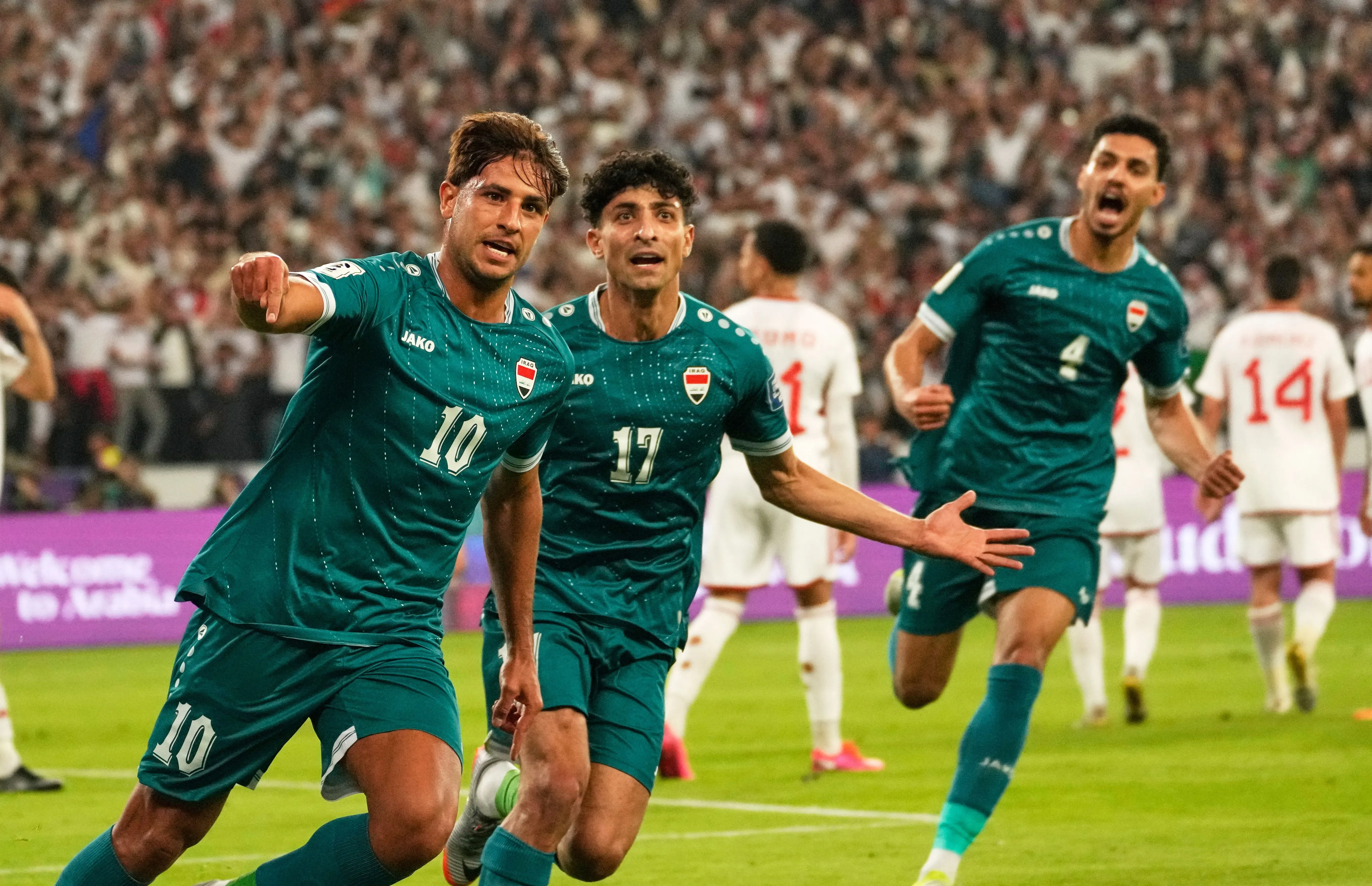 فرحة لاعبي المنتخب العراقي بعد تسجيل هدف في مباراة حاسمة، حيث يسعون للتأهل إلى كأس العالم 2026 وسط تحديات السفر بسبب الأوضاع في المنطقة.