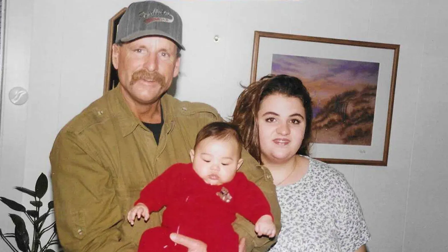 رجل مسن يحتضن طفلاً بينما تقف امرأة بجانبه، في لقطة عائلية تعكس اللحظات الدافئة قبل وفاة مايكل بورش في السجن.