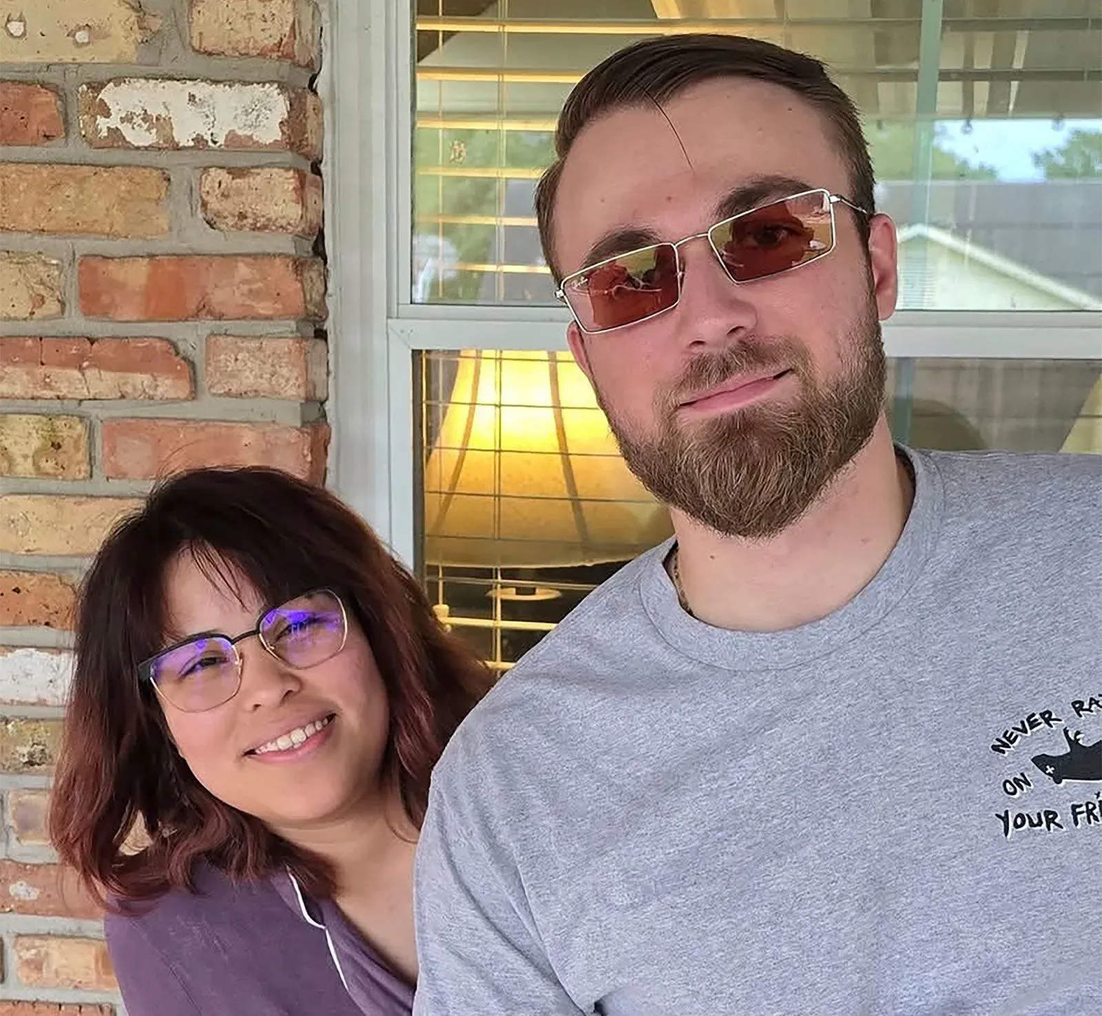 باولا كلواتر وزوجها أدريان يقفان معًا أمام نافذة، مع تعبيرات وجه سعيدة بعد إطلاق سراحها من الاحتجاز.