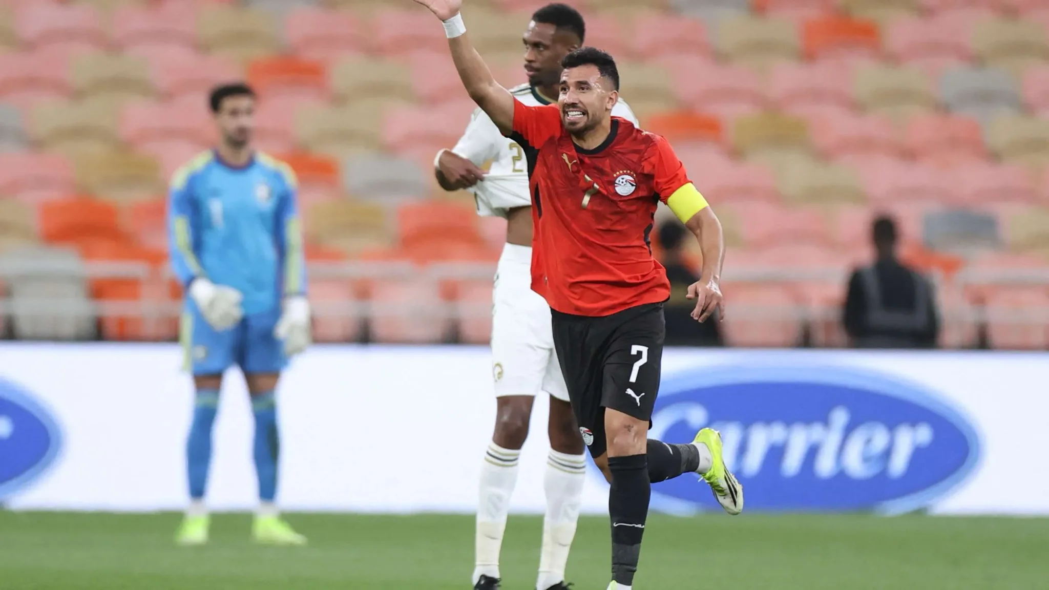 محمد صلاح يرتدي قميص منتخب مصر لكرة القدم أثناء مباراة، مع إشارة حيوية تدل على قيادته في الملعب، تعبيرًا عن دوره البارز في تاريخ اللاعبين المصريين في الدوري التركي.