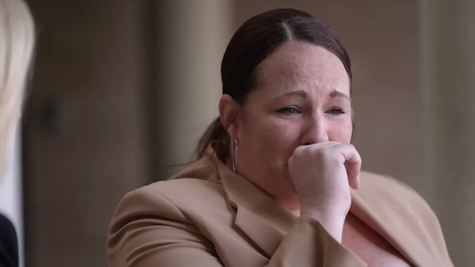 امرأة تبكي في مقابلة، تعبر عن مشاعر الألم والمعاناة الناتجة عن الإدمان على الفنتانيل، وتشارك تجربتها في التعافي.