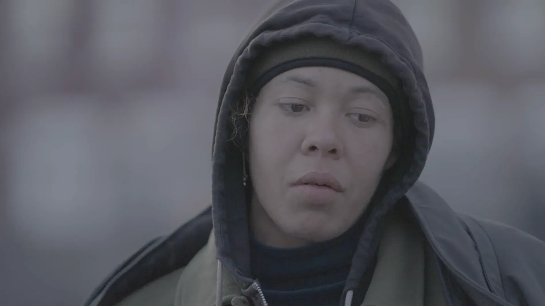 امرأة تبدو حزينة ومرهقة، ترتدي سترة داكنة وقبعة، تعكس معاناتها مع الإدمان وتحديات التعافي من الفنتانيل.