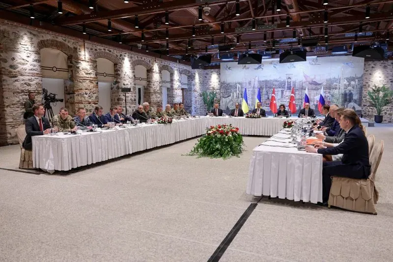 اجتماع بين ممثلين عن أوكرانيا وروسيا وتركيا، مع وجود أعلام الدول، في إطار محادثات دبلوماسية حول النزاع.