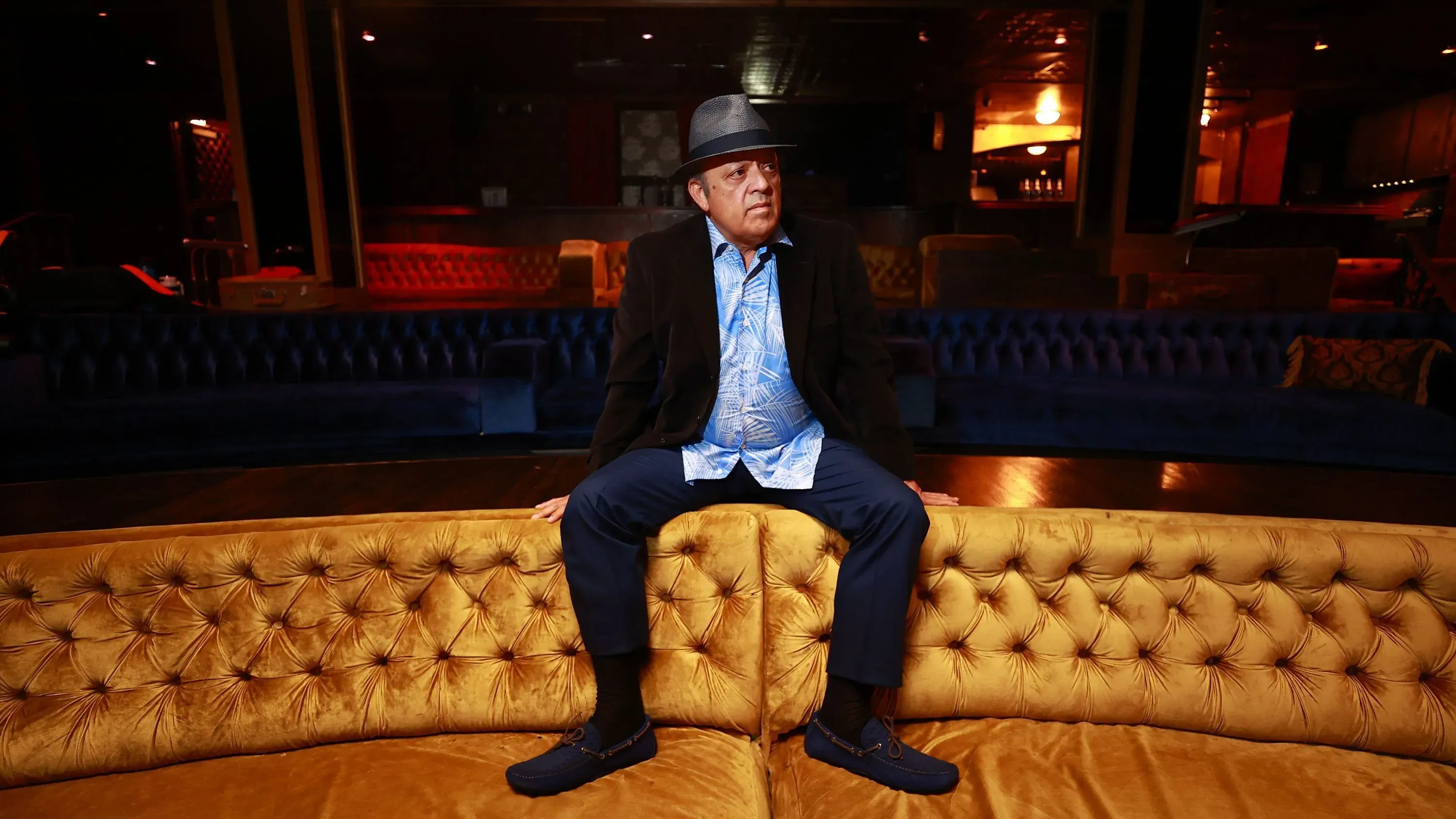 بول رودريغيز، الممثل الكوميدي البالغ من العمر 70 عامًا، يجلس على أريكة في موقع داخلي، بعد إلقاء القبض عليه بتهمة حيازة المخدرات.