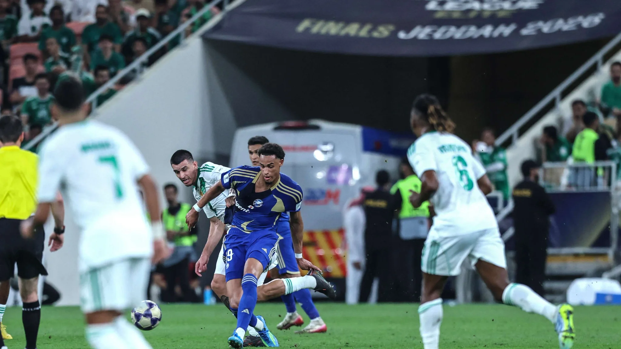 لاعب من الأهلي السعودي يراوغ لاعبًا من Auckland FC في مباراة كأس تحدّي الأندية 2026 بجدة وسط حضور جماهيري كبير.