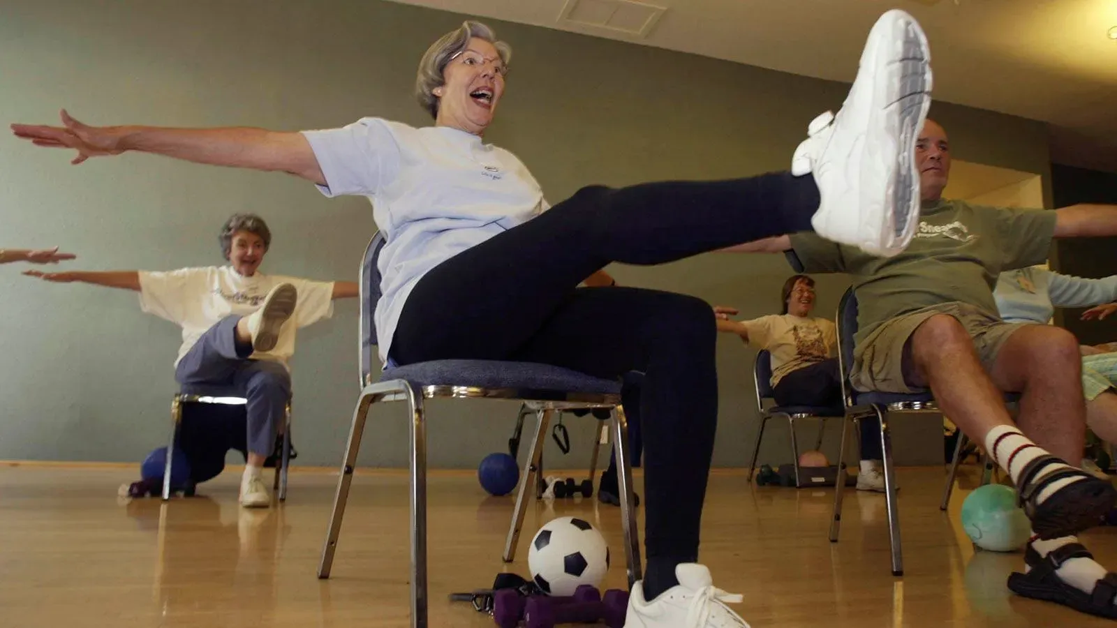 نساء مسنات يمارسن تمارين رياضية في صف جماعي، مما يعكس أهمية النشاط البدني لصحة المرأة بعد انقطاع الطمث.