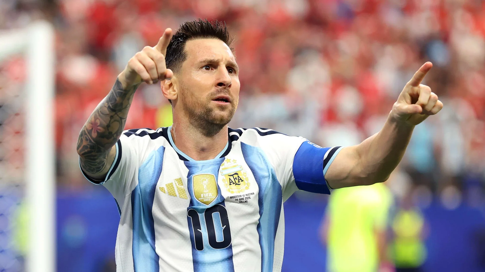ليونيل ميسي يرفع يديه ويشير في مباراة مع المنتخب الأرجنتيني، مرتدياً قميص رقم 10، في لحظة احتفال وتكريم لمسيرته الدولية.