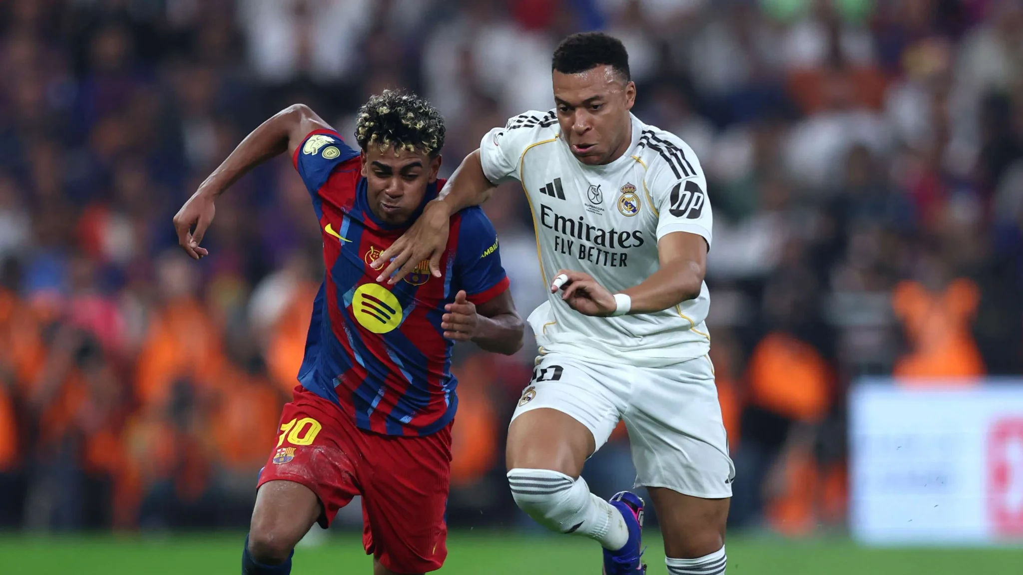 مبابي لاعب ريال مدريد يتنافس على الكرة مع لاعب برشلونة خلال مباراة كلاسيكو حماسية في الدوري الإسباني.