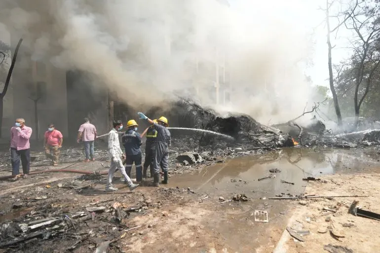 حطام طائرة دريملاينر 787 بعد تحطمها في منطقة مأهولة، مع فرق الإنقاذ تعمل على إخماد النيران والبحث عن الناجين.