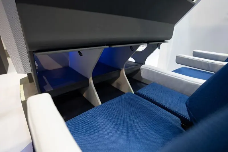 تصميم مقعد طائرة مبتكر ذو مستويين مع مساحة إضافية للأرجل، يهدف لتحسين تجربة السفر للركاب.