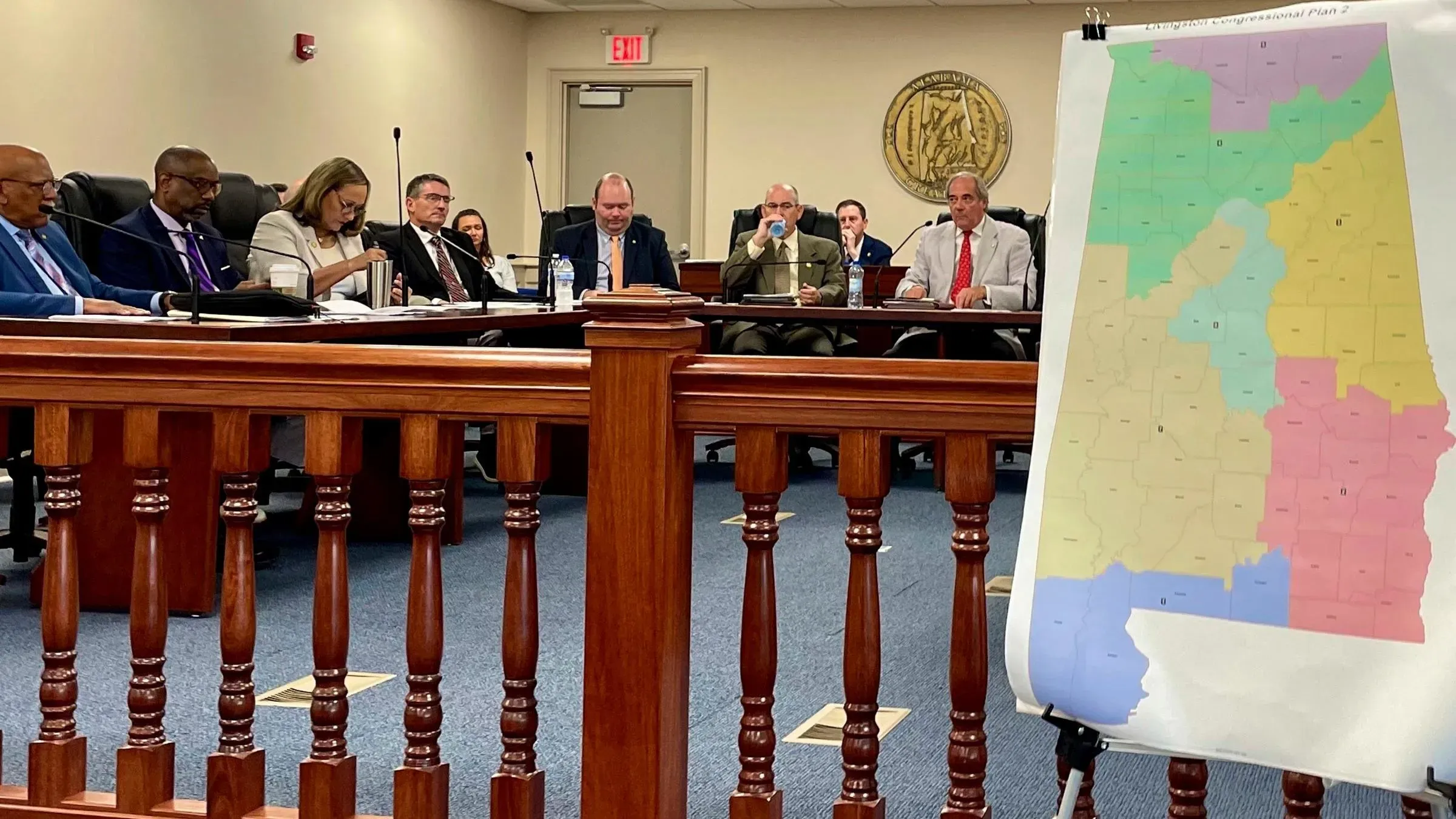 اجتماع لمناقشة خريطة الكونغرس الجديدة في ألاباما، مع عرض خريطة ملونة توضح الدوائر الانتخابية، وسط حضور عدد من الأعضاء.