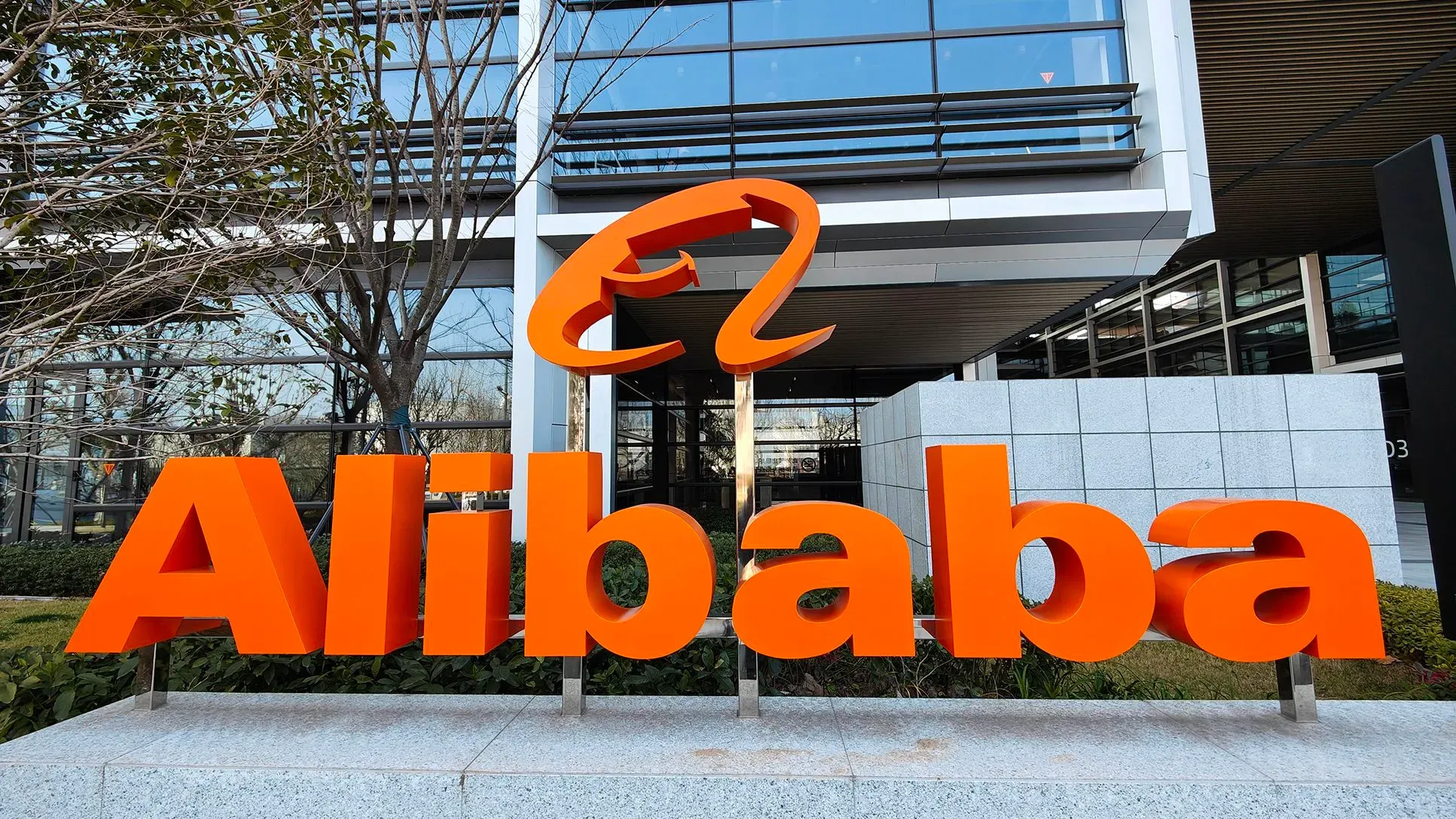 شعار شركة علي بابا باللون البرتقالي أمام مبناها، يرمز إلى ابتكاراتها في الذكاء الاصطناعي والتكنولوجيا المتقدمة.