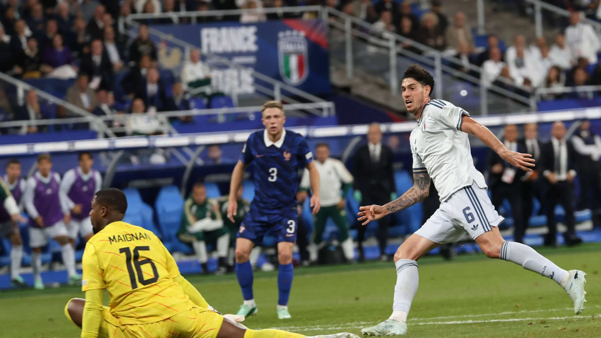 لاعب إيطالي يسدد الكرة نحو حارس مرمى فرنسا ماينان في مباراة دوري الأمم الأوروبية بين فرنسا وإيطاليا باستاد دو فرانس.