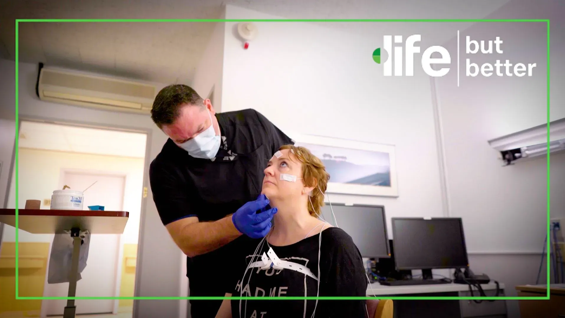 امرأة تتلقى تقييمًا طبيًا مع متخصص يرتدي كمامة، بينما يتم توصيل أجهزة مراقبة لها في بيئة طبية.