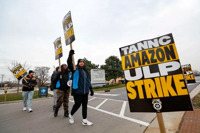 عمال أمازون يتظاهرون حاملين لافتات تطالب بحقوقهم، وسط أجواء باردة، أمام منشأة أمازون في كارولينا الشمالية.