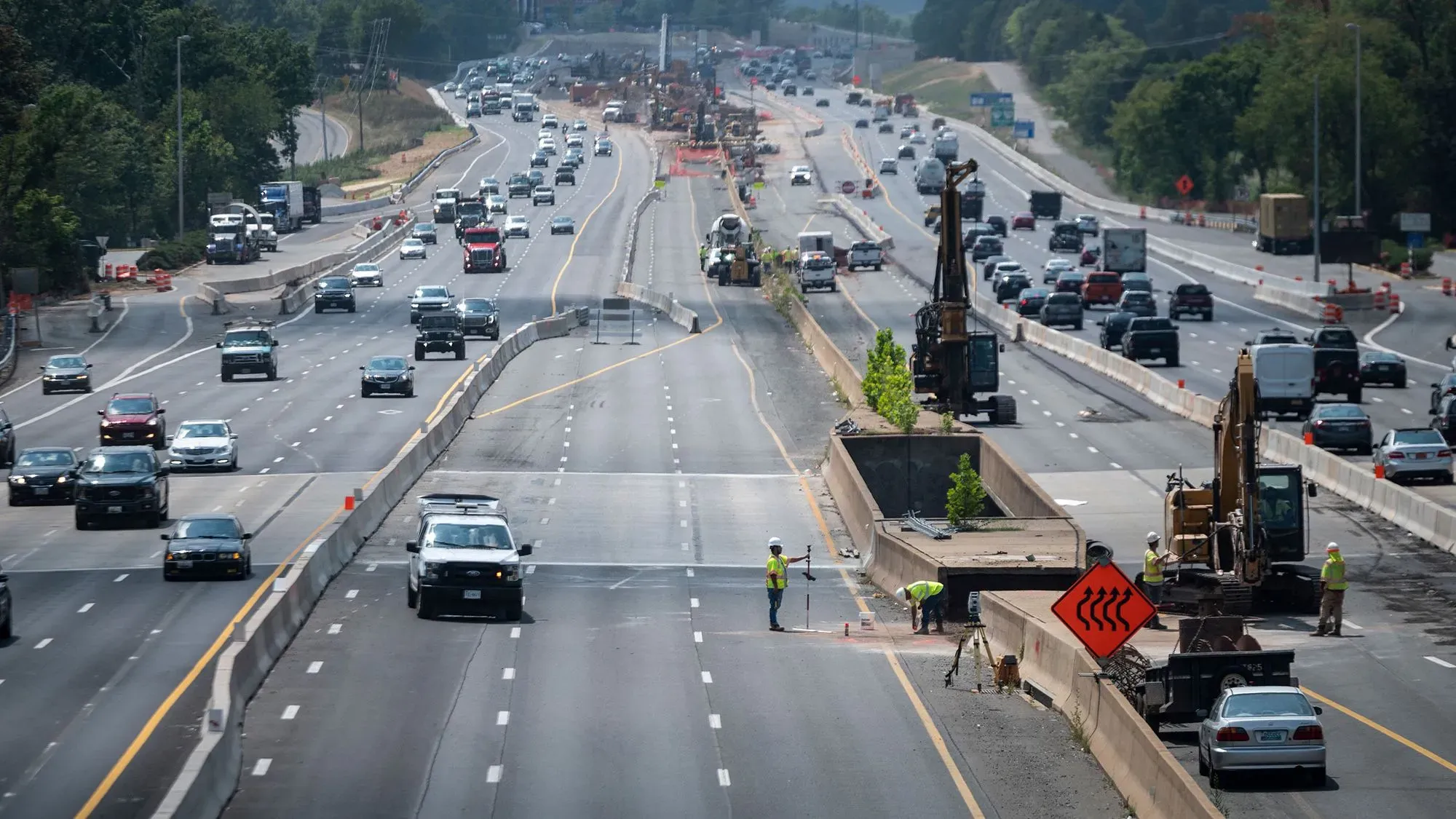 مشهد لطرق مزدحمة أثناء أعمال البناء، مع وجود عمال ومعدات ثقيلة. يعكس التحسينات في البنية التحتية الأمريكية.