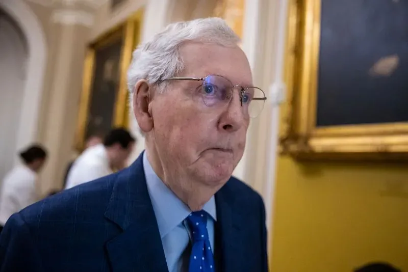 مitch mcconnell يتجول في مبنى الكابيتول، مع تعبير جاد، في سياق مناقشات سياسية حول إدارة ترامب والتضخم.
