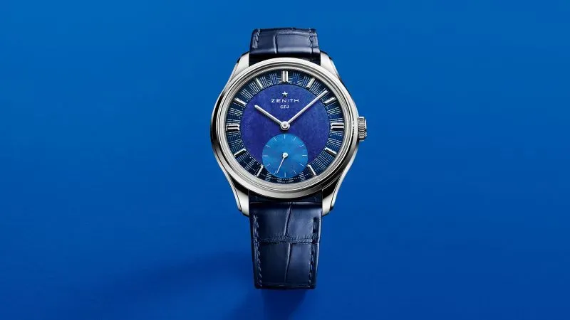 ساعة زينيث بتصميم أنيق، مع ميناء مزدوج بلونين مختلفين من الأحجار الكريمة، تعكس الفخامة والابتكار في صناعة الساعات.