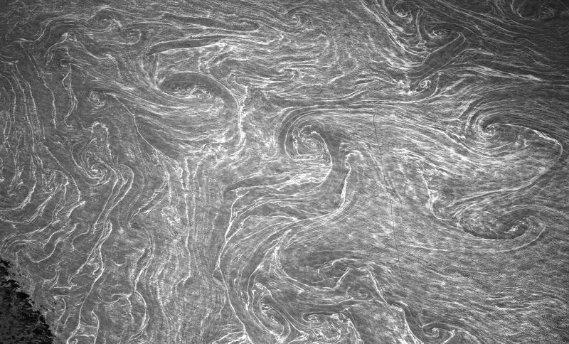 تظهر الصورة أنماط swirling في الماء، تعكس جمال الأرض من منظور الفضاء، كما يلتقطها رائد الفضاء دون بيتيت من محطة الفضاء الدولية.