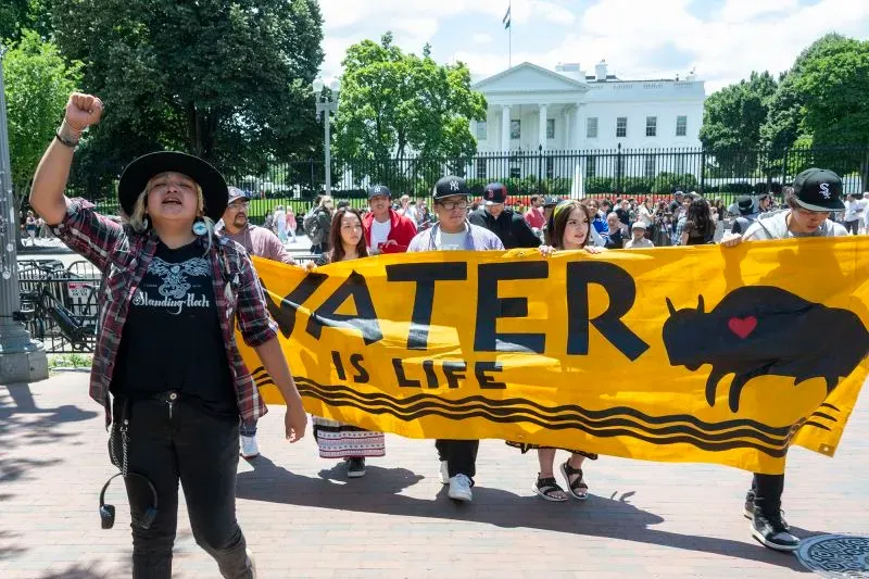 محتجون يحملون لافتة مكتوب عليها "الماء هو الحياة" أمام البيت الأبيض، تعبيرًا عن دعمهم لحماية المياه وحقوق السكان الأصليين.