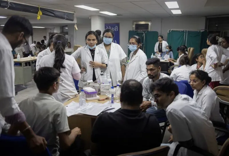 فريق من الأطباء والمساعدين في مستشفى أحمد آباد، يعملون على جمع عينات الحمض النووي من عائلات ضحايا حادث تحطم الطائرة.