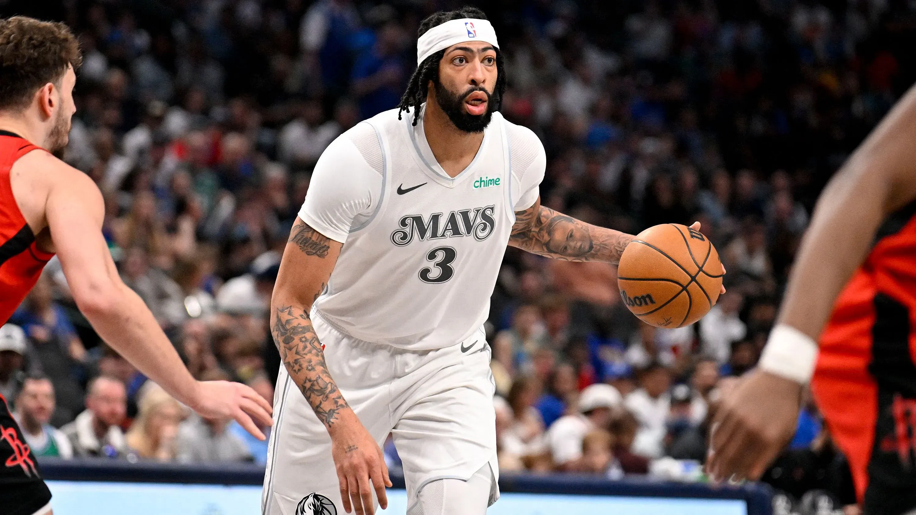 أنتوني ديفيس يحمل الكرة خلال مباراة مع دالاس مافريكس، مسجلاً 26 نقطة و16 كرة مرتدة، وسط تفاعل حماسي من الجمهور.