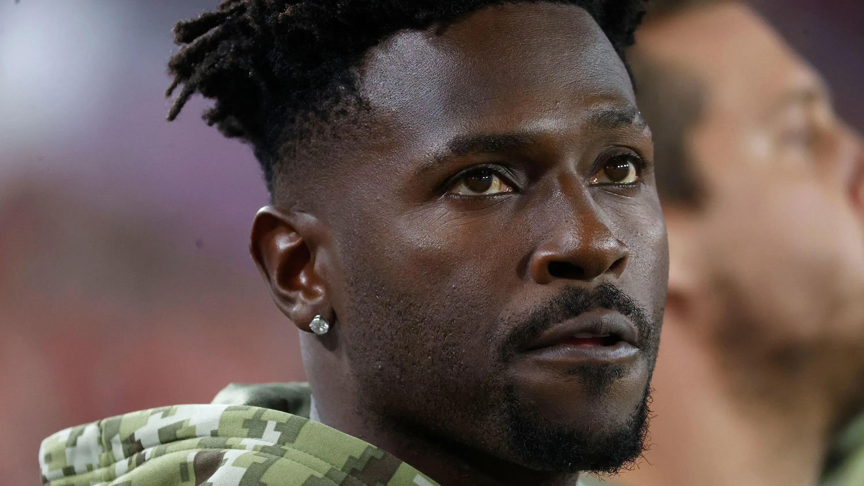 تظهر الصورة أنطونيو براون، لاعب كرة القدم الأمريكي السابق، وهو ينظر بجدية، مما يعكس توتر الأحداث الأخيرة التي شهدها في ميامي.