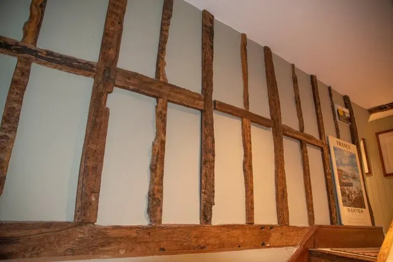 جدار خشبي قديم يظهر في منزل تاريخي، مع تفاصيل فنية تعكس العمارة الأنجلوسكسونية، مرتبطًا بموقع قصر هارولد.