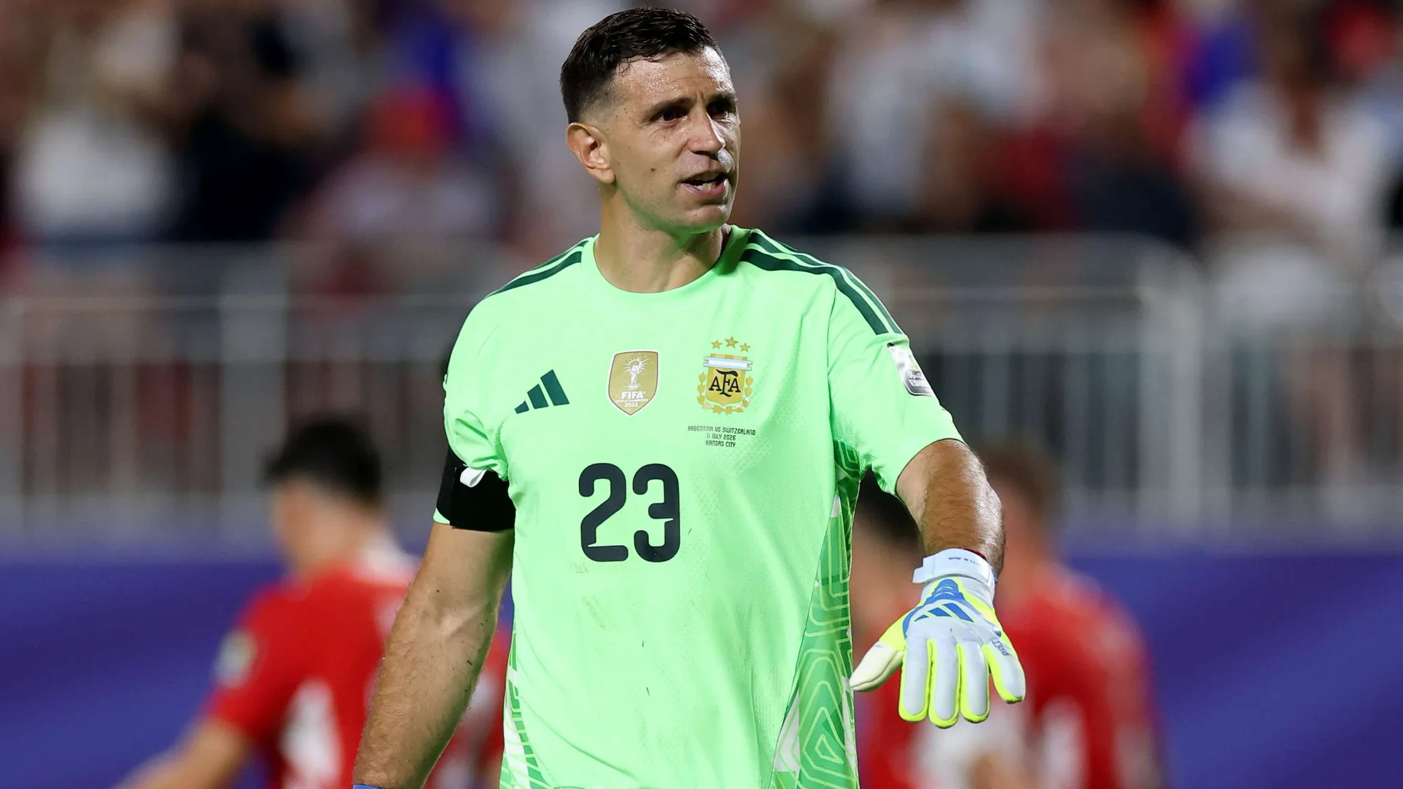 إيميليانو مارتينيز حارس منتخب الأرجنتين يرتدي زي الحراسة الأخضر خلال مباراة كأس العالم، مع توتر علاقته بنادي أستون فيلا ورغبته في الانتقال.