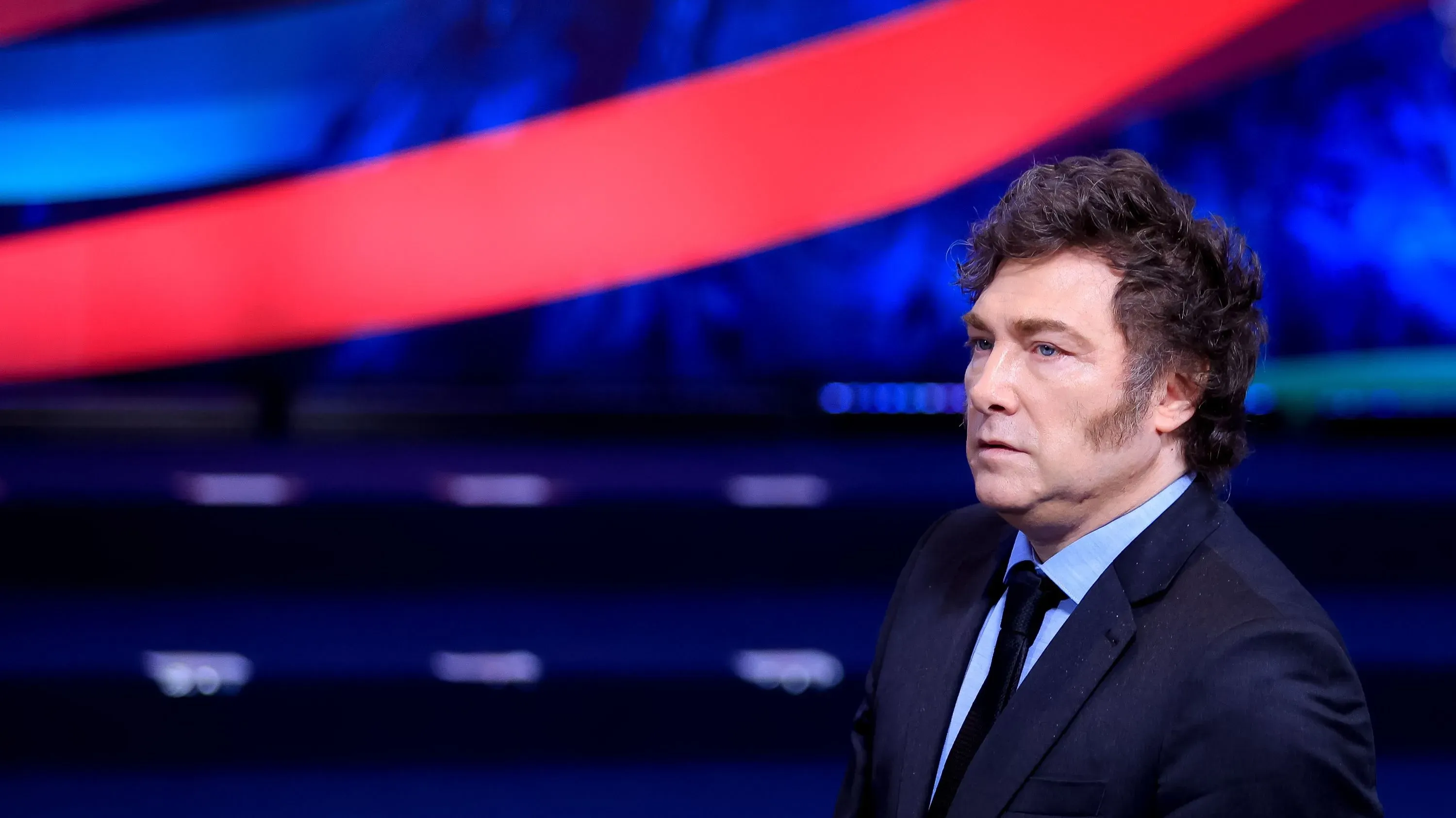 الرئيس الأرجنتيني خافيير ميلي يتحدث خلال مقابلة تلفزيونية، مع خلفية ملونة، بعد انتقادات لترويجه لعملة مشفرة جديدة.