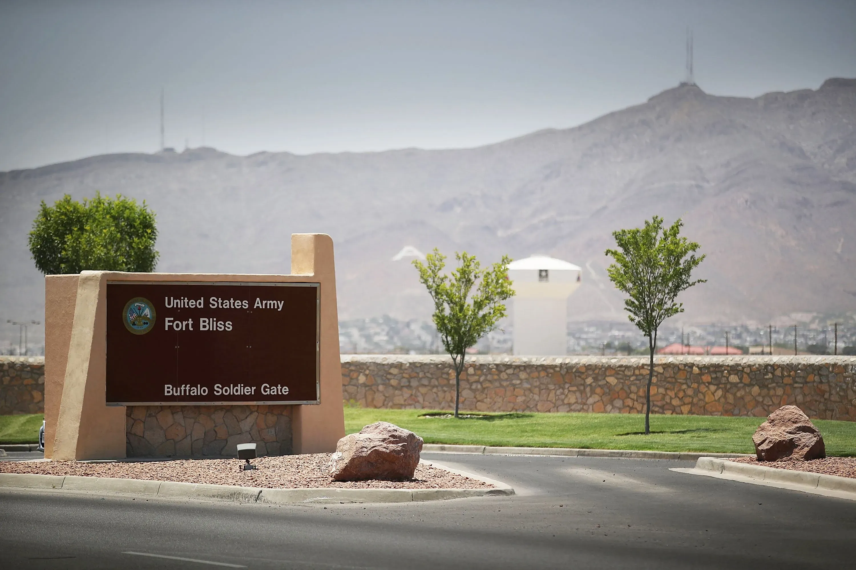 لافتة مدخل قاعدة فورت بليس العسكرية في تكساس، مع تلال خلفية، تشير إلى اعتقال جندي بتهمة التجسس.