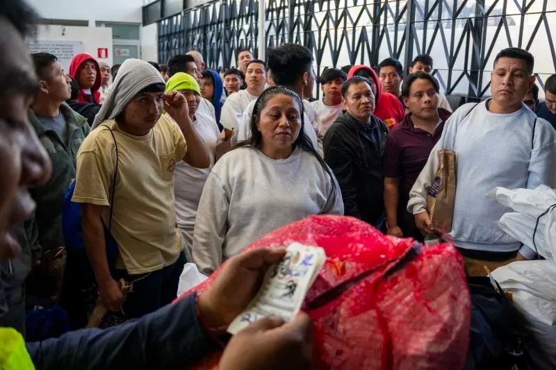 حشود من المهاجرين العائدين في مركز استقبال غواتيمالا، بعد ترحيلهم من الولايات المتحدة، ينتظرون استلام أمتعتهم.