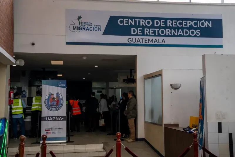 مدخل مركز استقبال العائدين في غواتيمالا، حيث يتجمع المهاجرون العائدون وسط وجود مسؤولين وتسهيلات للترحيب بهم.