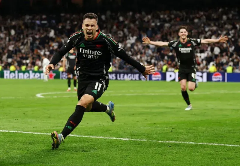 احتفال لاعب أرسنال جابرييل مارتينيلي بعد تسجيله هدفًا في مرمى ريال مدريد خلال مباراة دوري أبطال أوروبا، وسط جمهور متحمس.