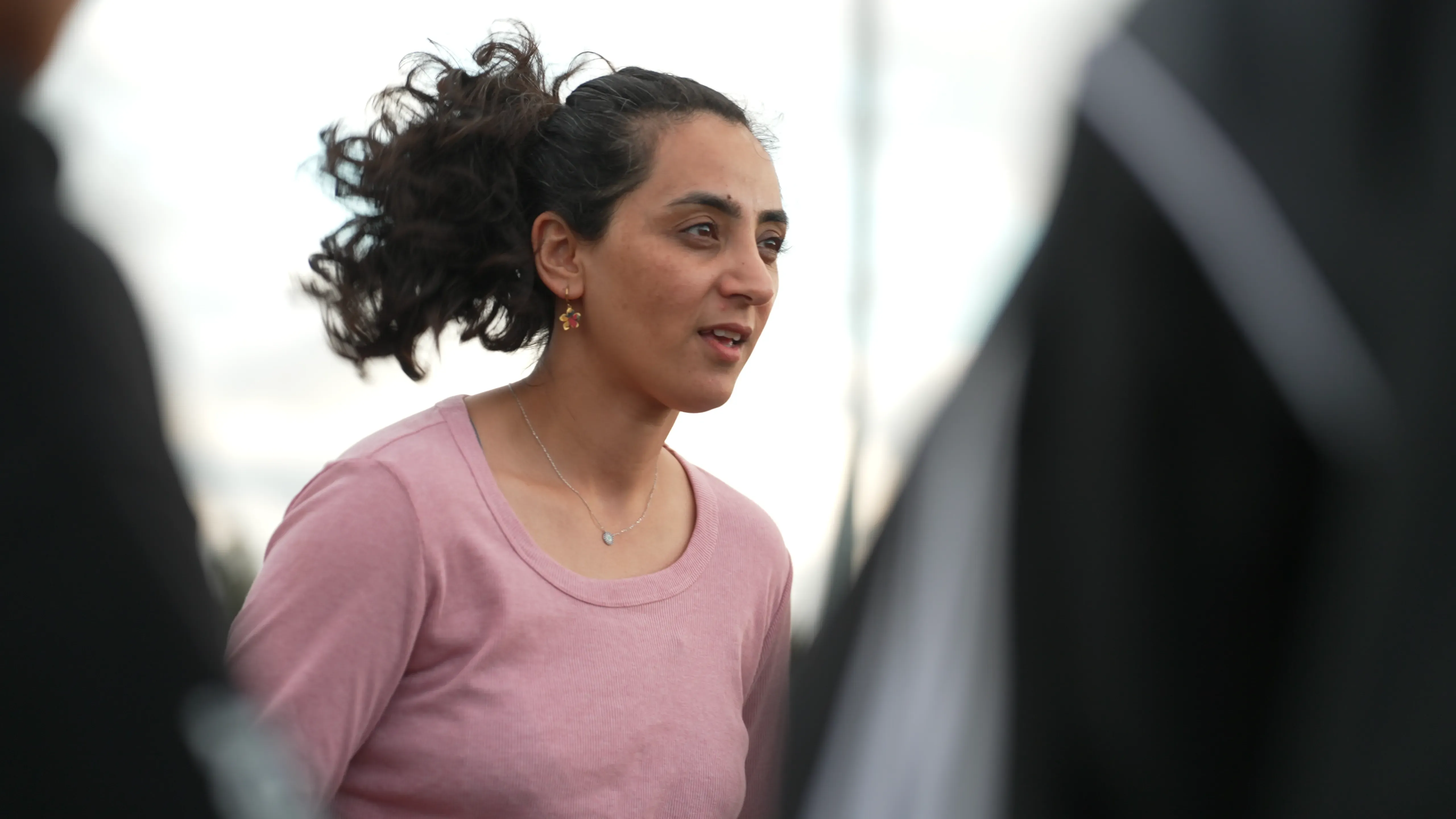 شابة أفغانية تتحدث بقلق أثناء تدريب فريق اللاجئات الأفغانيات، تعكس مشاعر الأمل والتحدي في ظل الظروف الصعبة.